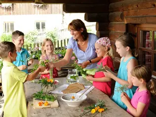 Gastgeberin mit Kindern am Kochen