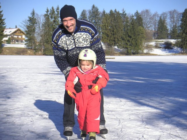 Vater und Kind beim Schlittschuhlaufen