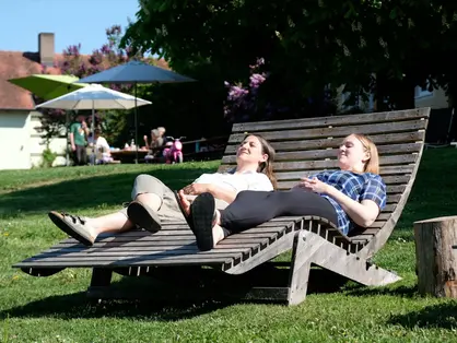Eltern auf der Liege © Andreas Kern Während die Kinder spielen, entspannen die Erwachsenen im Garten