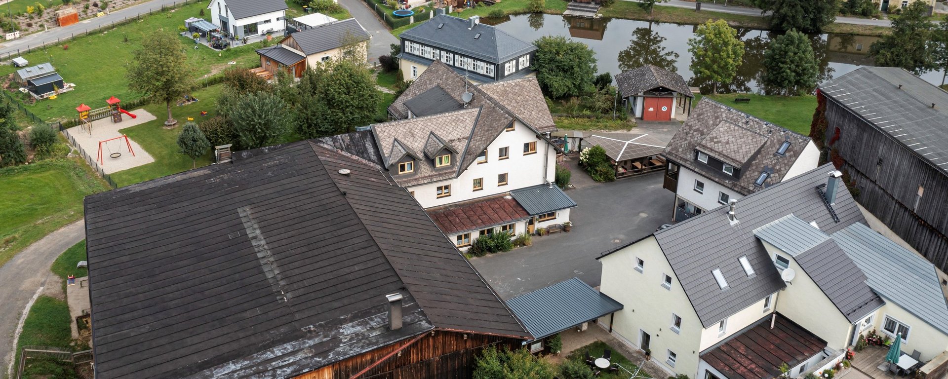 Luftaufnahme von einem dörflichen Ferienhof in Bayern