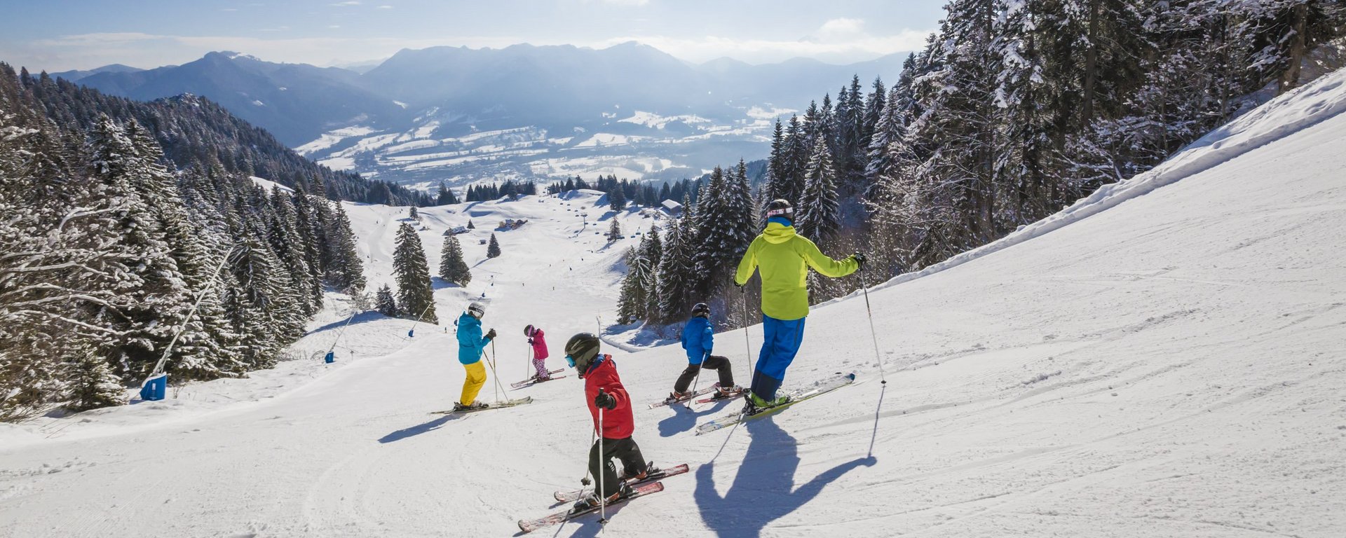 Familie auf sonniger Skipiste am Brauneck bei Lenggries im Tölzer Land