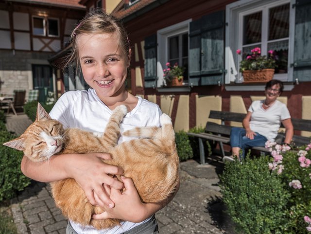 Mädchen mit Katze auf dem Bauernhof Hellbachhof in Simmershofen