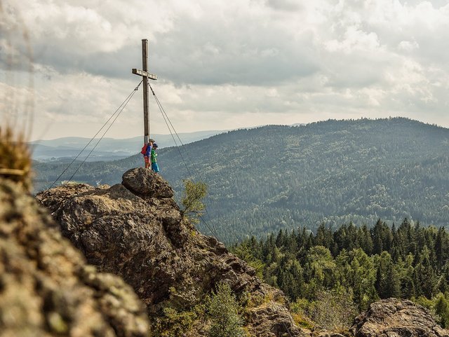 Wanderer am Gipfelkreuz des Großen Arber im Bayerischen Wald