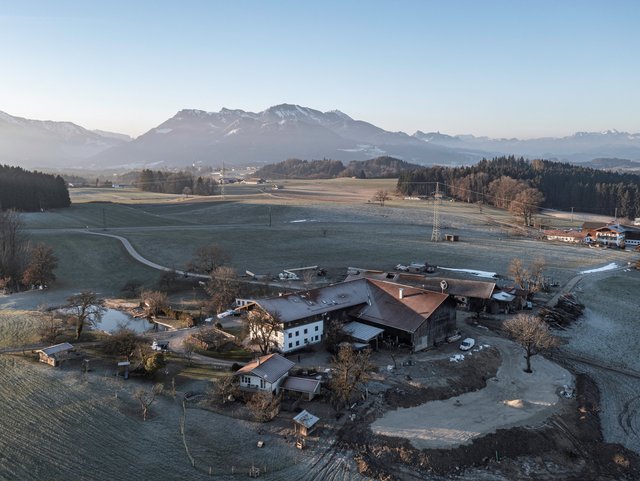 Luftaufnahme des Hofes mit idyllischer Bergkulisse