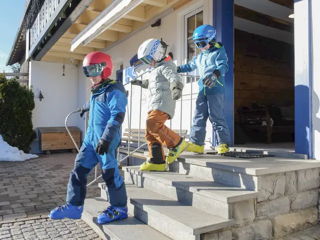 Kinder gehen aus der Tür zum Skifahren