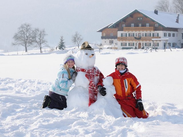 Schneemannbauen im Winterurlaub auf dem Bauernhof in der Region Chiemsee