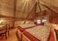 uriges Schlafzimmer unter einer Holzkuppel in der Hütte auf dem Bauernhof