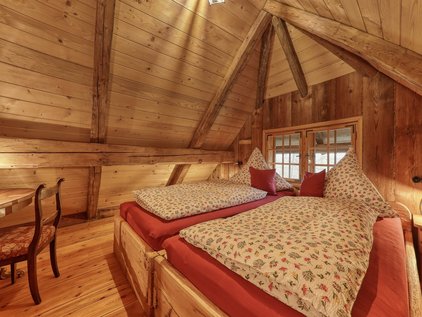 uriges Schlafzimmer unter einer Holzkuppel in der Hütte auf dem Bauernhof
