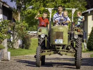 Kinder mit Gastgeber auf Traktor