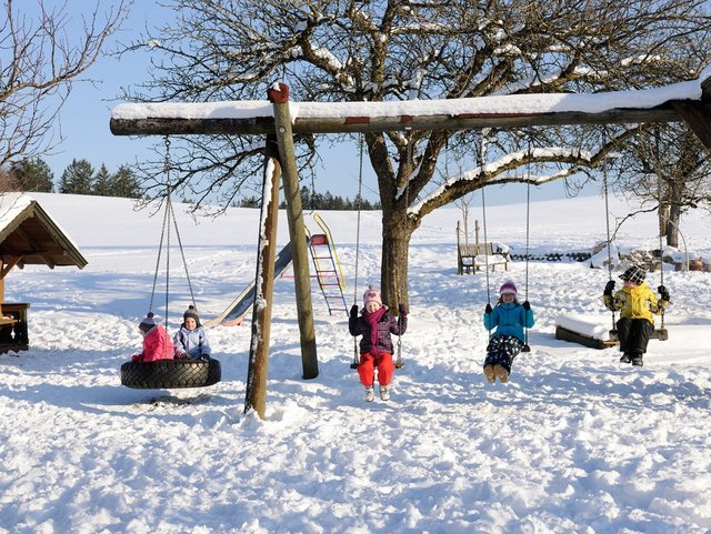 Spielplatz auf dem Bauernhof im Winter in der Region Chiemsee