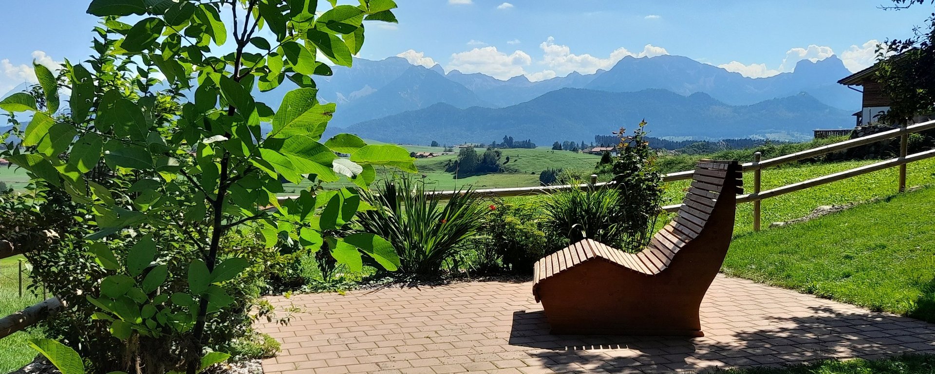 Auf der Holzliege auf dem Bauernhof in Allgäu blicken 