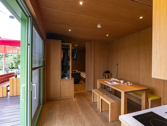 Gemütlicher Wohn- und Schlafbereich aus Holz im RadAppartment der Weihersmühle